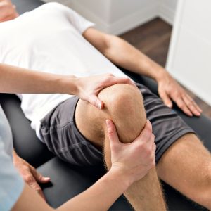 chiropractor adjusting a person's knee