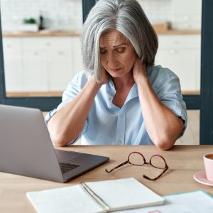 woman with neck pain working on computer